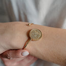 Bracciale rigido con moneta centrale